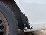 a white car that has been damaged and is sitting on the side of the road