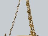 a close up of a bowl hanging from a chain on a gray background