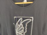 a t shirt with a butterfly on it hanging on a hanger