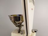 a scale and a bowl on a stand on a table