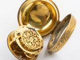 an image of a gold pocket watch sitting on top of a white surface