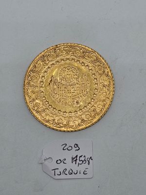a close up of a gold coin on a white surface
