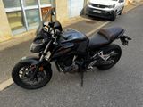 une moto noire garée sur le bord de la route