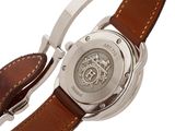 a close up of a watch with a brown strap on a white background