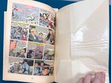 a person holding a comic book open on a table