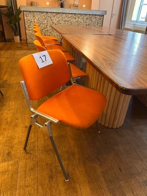 many orange chairs in a room with a wooden table
