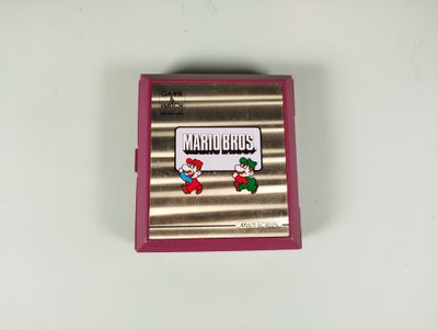 un jeu Nintendo posé sur une table blanche, dans un boîtier rose