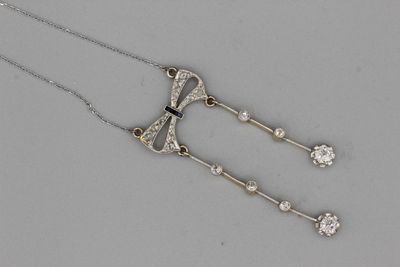 Chaine en or retenant un noeud serti de diamants et deux pam…