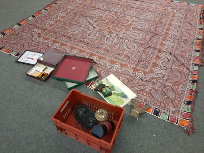 un tapis et une boîte de livres posés par terre
