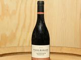 une bouteille de vin posée sur un tonneau