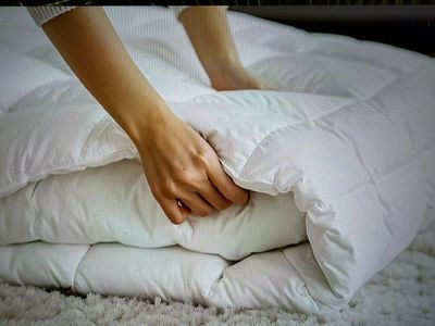a person that is laying on a bed with a pillow