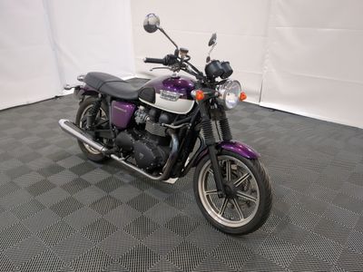 une moto violette et noire garée dans une pièce au sol carrelé
