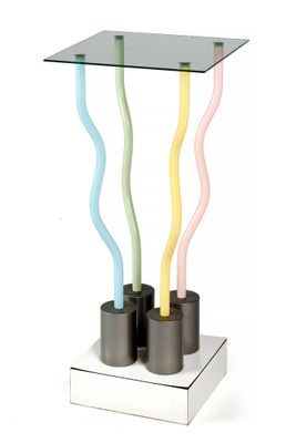 une table en verre sur laquelle sont posés trois bâtonnets de couleurs différentes