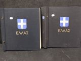 two black books with blue and white logos on them sitting on a black surface