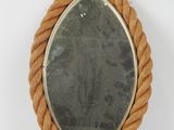 an oval mirror with rope wrapped around it on a white surface