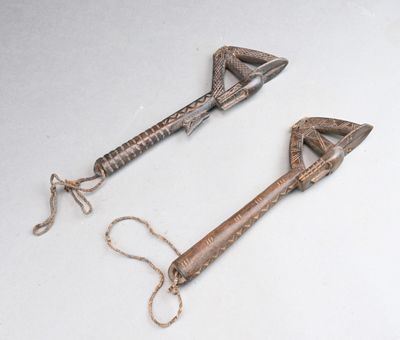 une paire d'anciens outils en bois et en métal posés sur une surface blanche