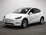a white tesla suv parked in a room with a checkered floor