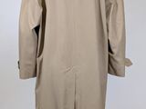 the back view of a beige coat on a mannequin stand