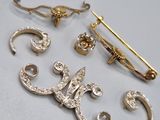 a lot of gold and silver brooches on a table