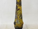a yellow vase with a black base on a white background