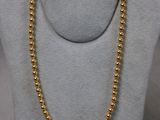 un collier de perles dorées sur un mannequin