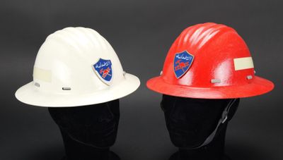deux casques de chantier sont posés l'un à côté de l'autre sur une surface noire
