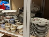 many plates and bowls on the shelves in the store