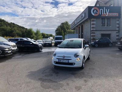 des voitures sont garées dans un parking devant un bâtiment