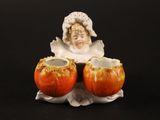 une figurine représentant une femme tenant deux pommes