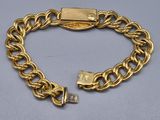 a close up of a gold chain bracelet with a lock