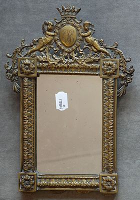un miroir avec un cadre doré sur le mur