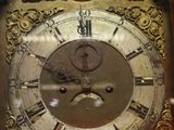 a wooden grandfather clock with a gold face on it
