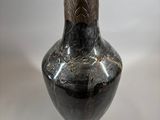 a black vase that has a design on it