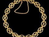 un collier en or avec une chaîne et un fermoir sur fond noir
