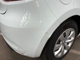 the rear end of a white car with a denting dent on it