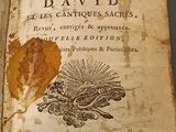 an old book with a leaf on it sitting on a table