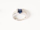 gros plan d'une bague en saphir bleu et diamant sur une surface blanche
