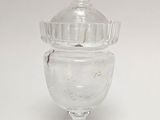 a clear glass jar with a lid on a white table