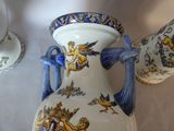 a large vase with a blue handle on a table