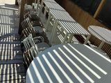 many tables and chairs on the deck of a restaurant
