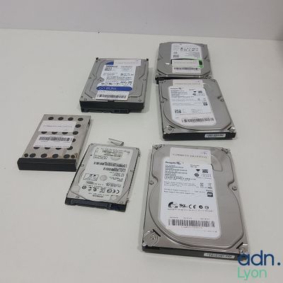 quatre disques durs posés les uns à côté des autres sur une table blanche