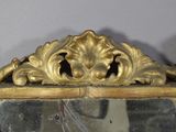 a mirror that has a gold frame on it