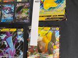 several pokemon cards are on a black table with a white tag