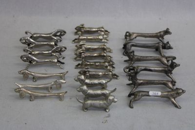 Plusieurs figurines de chiens en argent sont alignées sur une table