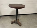 une petite table avec un plateau en bois sur un sol en béton