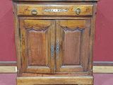 un petit meuble en bois surmonté d'une porte