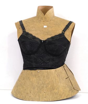 une photo d'un mannequin portant un haut de soutien-gorge noir et une jupe beige