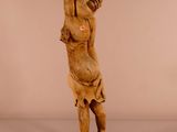 une statue en bois représentant un homme tenant une balle