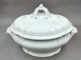 a white bowl with a lid sitting on a table