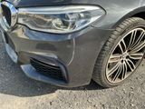 the front end of a gray bmw car parked in a parking lot